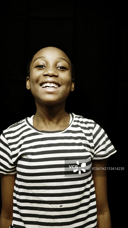 黑人背景上9岁小学年龄的非裔美国女孩的可爱快乐肖像图片素材