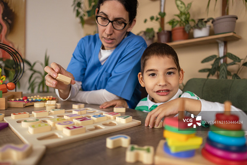 护士帮助自闭症儿童学习字母图片素材