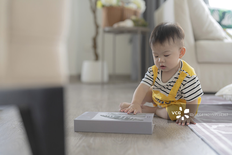 快乐的亚洲宝宝在家里练习爬行，玩耍图片素材