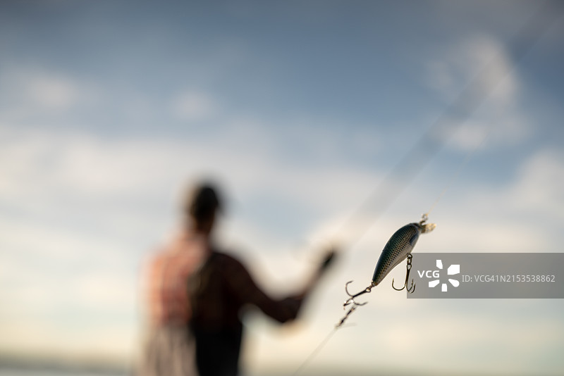 渔民在河边用鱼竿钓鱼特写图片素材