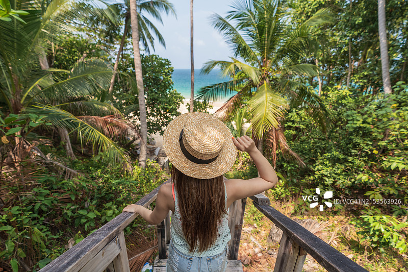 女人走在普吉岛奈通海滩的木楼梯上图片素材