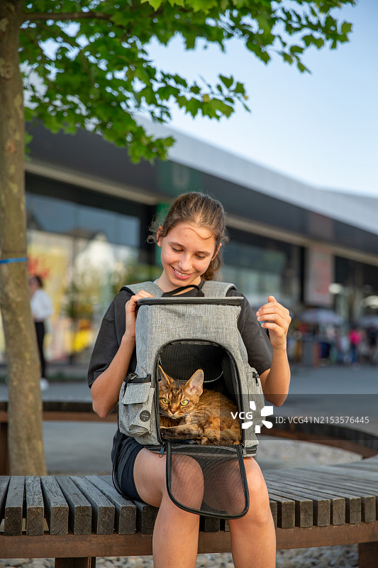 青少年宠物主人和她的德文卷毛猫在猫背包里图片素材