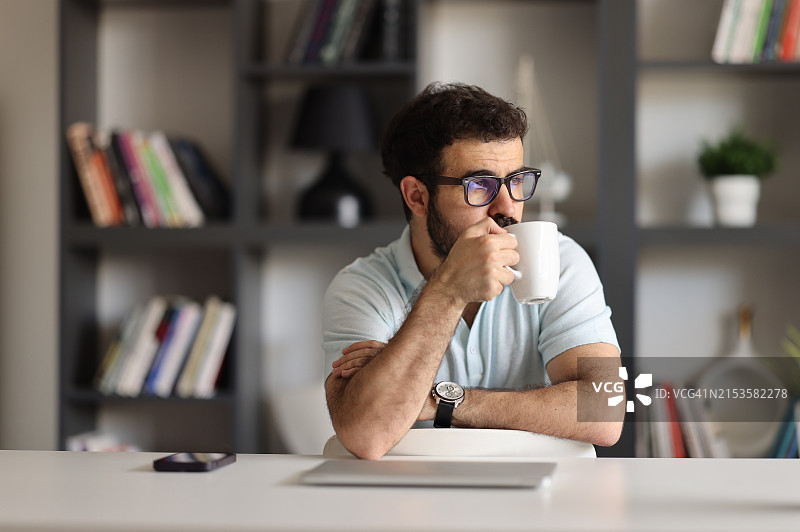 戴时尚眼镜的严肃自由职业者使用笔记本电脑工作图片素材