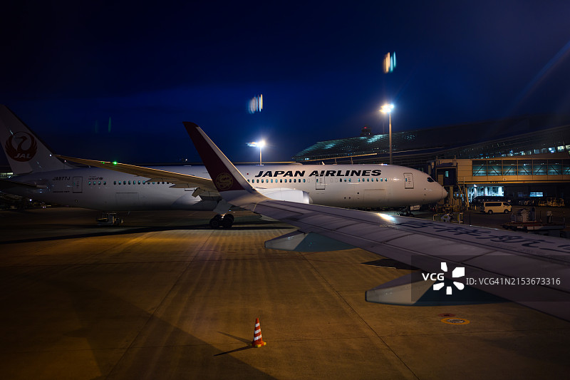 夜晚，日本航空飞机停靠在名古屋中部国际机场停机坪上图片素材