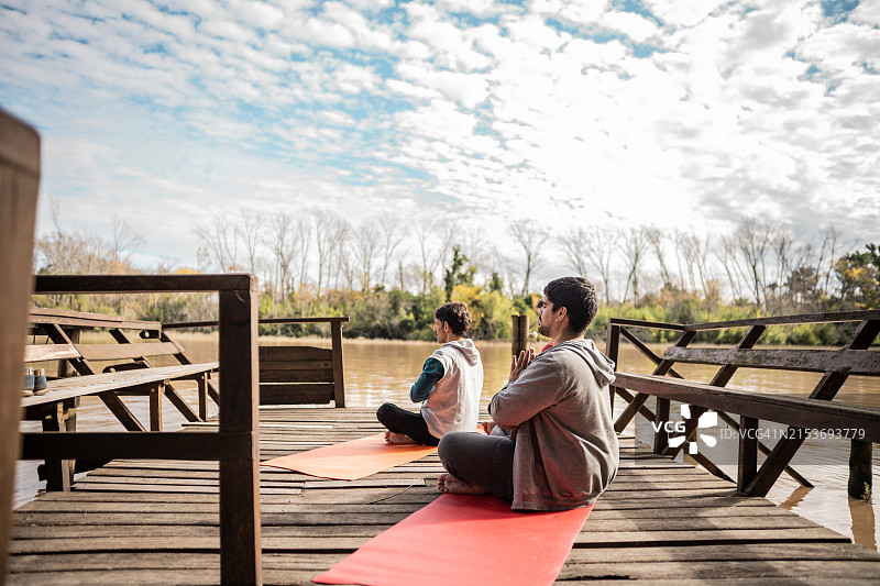 朋友在户外码头练习瑜伽图片素材