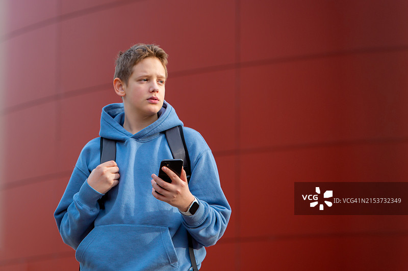 深切的担忧：身穿蓝色连帽夹克的青少年在反思图片素材