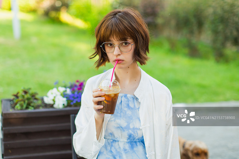 年轻女人喝冰咖啡，夏季 отдыха图片素材