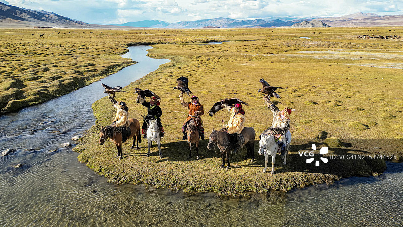 蒙古西部巴彦乌列盖省的哈萨克族猎鹰人骑马，金雕展翅图片素材