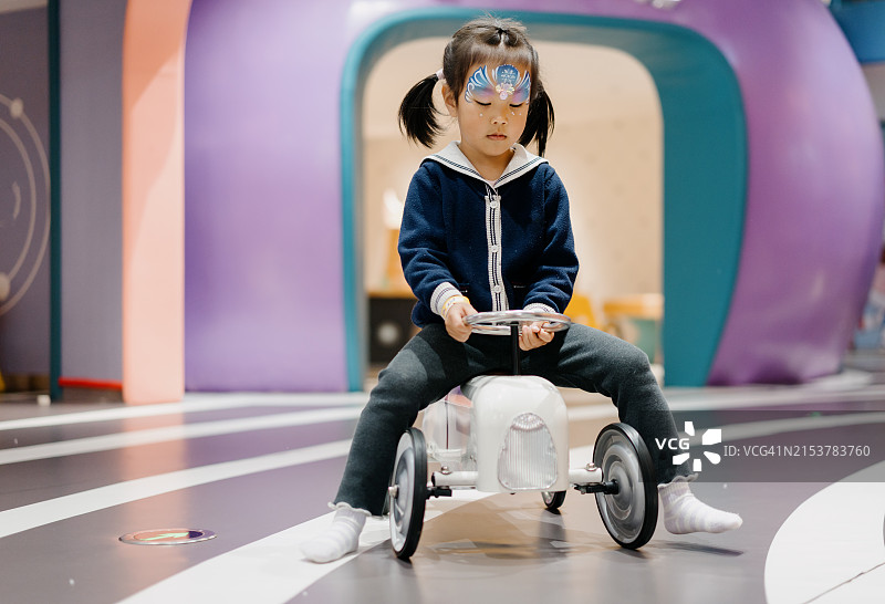 在游乐场玩玩具车的亚洲小女孩图片素材