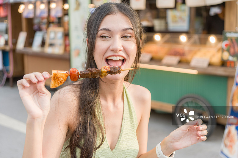 漂亮女人享用街头美食烧烤图片素材