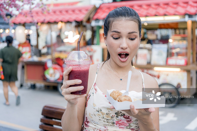 年轻女子享用街头美食图片素材