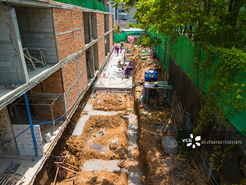 航拍视角：水泥、钢铁、机械和大量劳动力构成的建筑工地图片素材