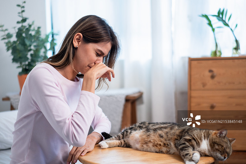 女人在猫附近打喷嚏图片素材