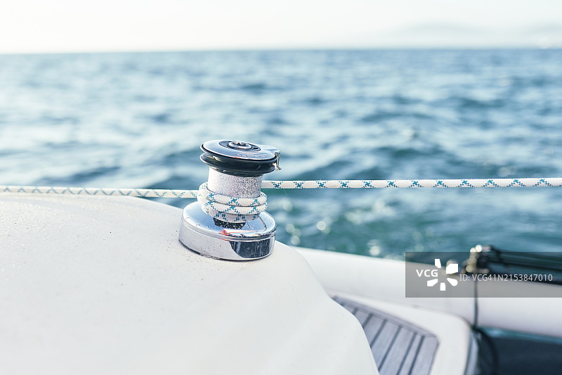 帆船上带有绳索的绞盘特写，背景是平静的海面和晴朗的天空图片素材