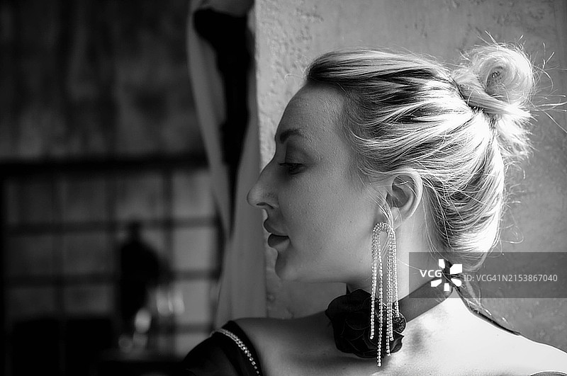 阳光和阴影下，年轻时尚美丽女性的窗边黑白肖像照图片素材