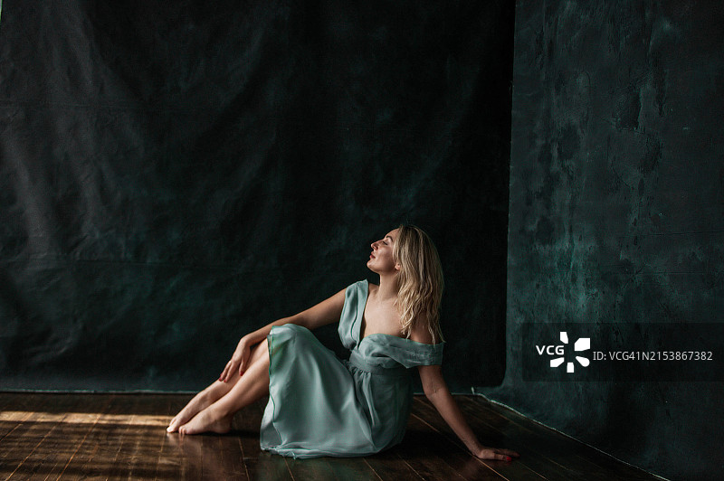 在一个阳光明媚的日子里，一个年轻美丽的女人在房间里的肖像图片素材