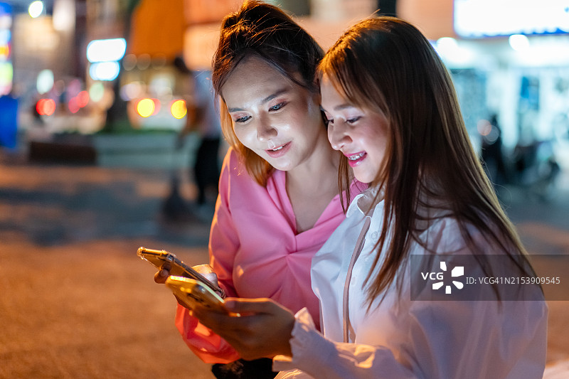 使用手机App与朋友直播互动的亚洲年轻女性图片素材