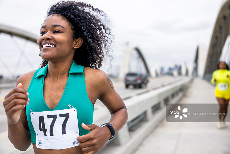 两位黑人女孩在城市里跑马拉松。图片素材