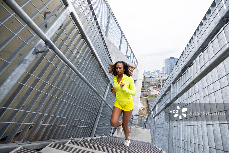 年轻黑人妇女在锻炼时跑上楼梯图片素材