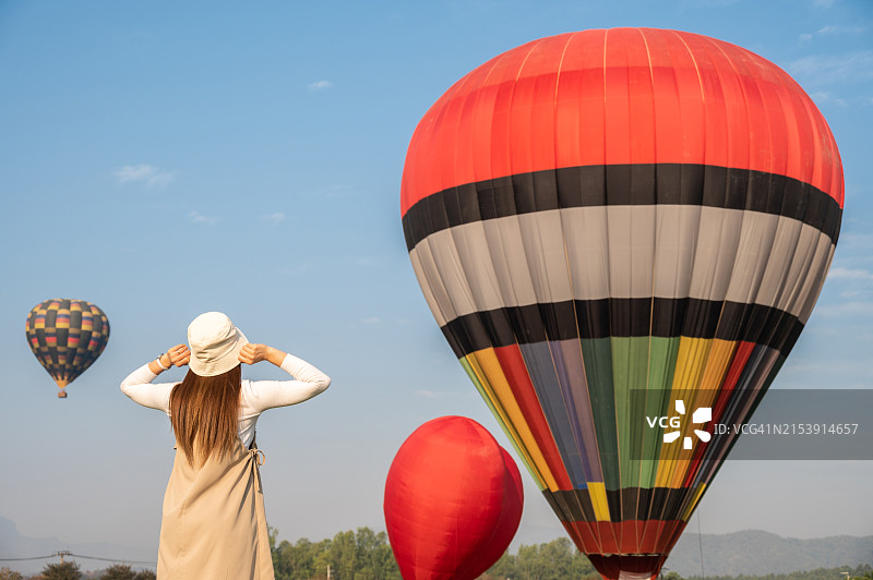 快乐的亚洲女性参观泰国清莱省的气球节。热气球节每年在许多地方举行图片素材