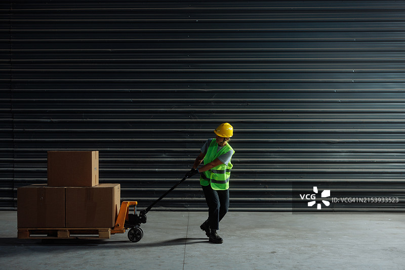 女仓库工人拉动托盘车图片素材