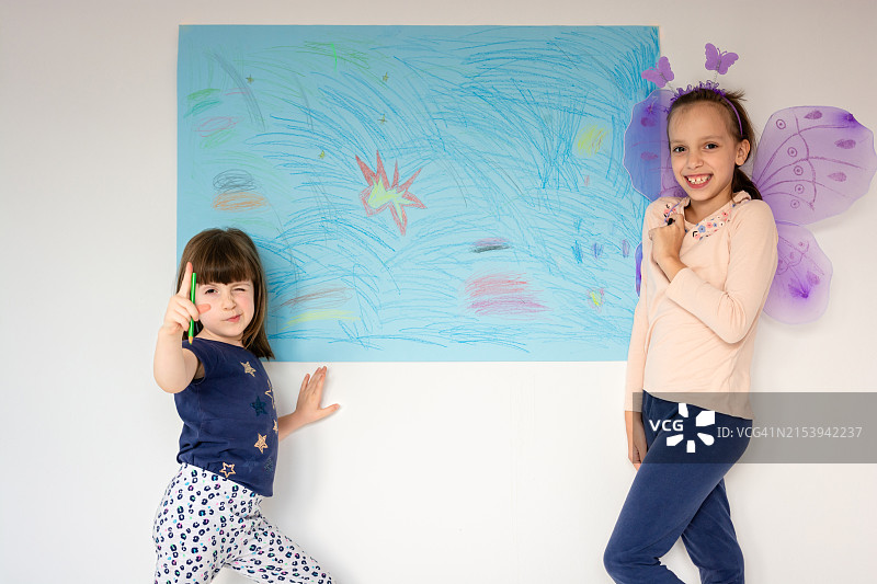 两个女孩站在绘画作品前图片素材
