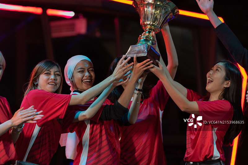 手捧奖杯的亚洲女运动员图片素材