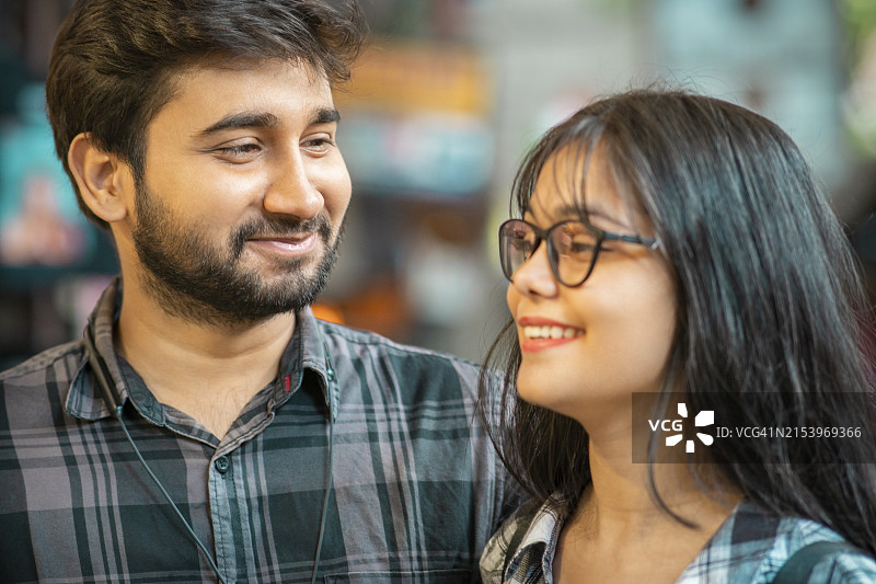 面带微笑的年轻男子看着女友的肖像图片素材