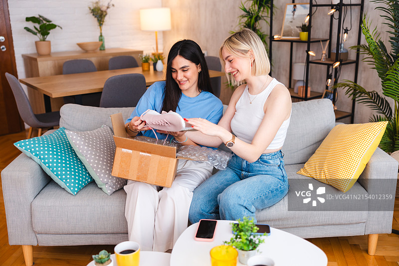 两位年轻女性在家打开包裹图片素材