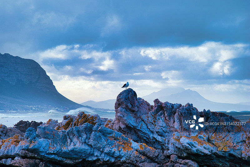 男人坐在岩石上欣赏天空图片素材