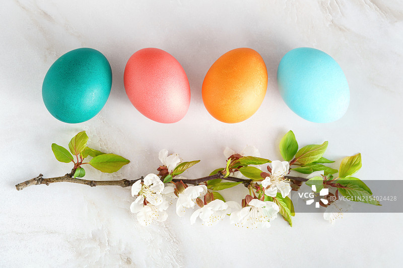 桌子上摆放的彩色复活节彩蛋和鲜花特写图片素材