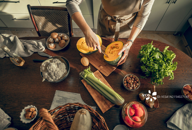 年轻女人切蔬菜图片素材