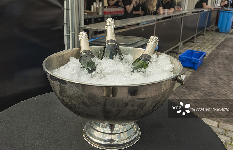 装满冰块和香槟酒瓶的银色碗图片素材