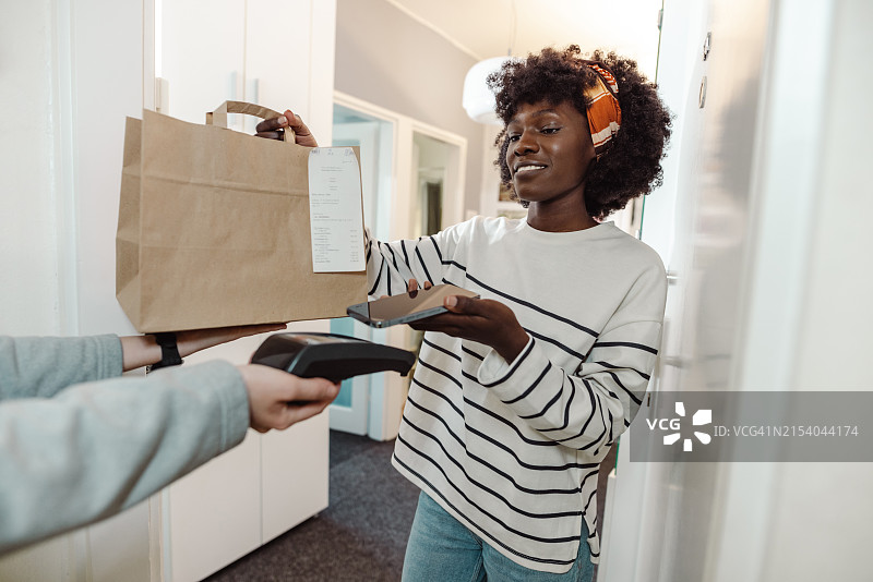 通过智能手机在门口进行非接触式支付图片素材