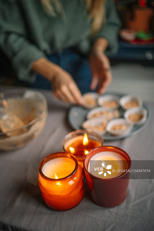 点燃桌上蜡烛的女子（腰部视角）图片素材