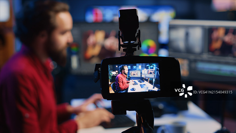 摄像师在屏幕模型上使用专业软件进行视频编辑图片素材