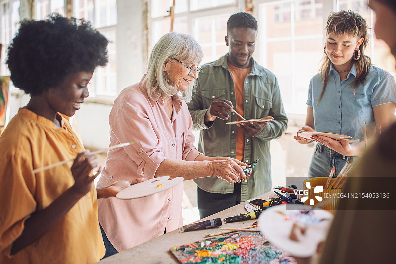 美术课进行中：老师指导有抱负的画家图片素材