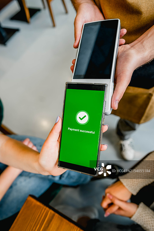 女人在咖啡馆用智能手机付款图片素材