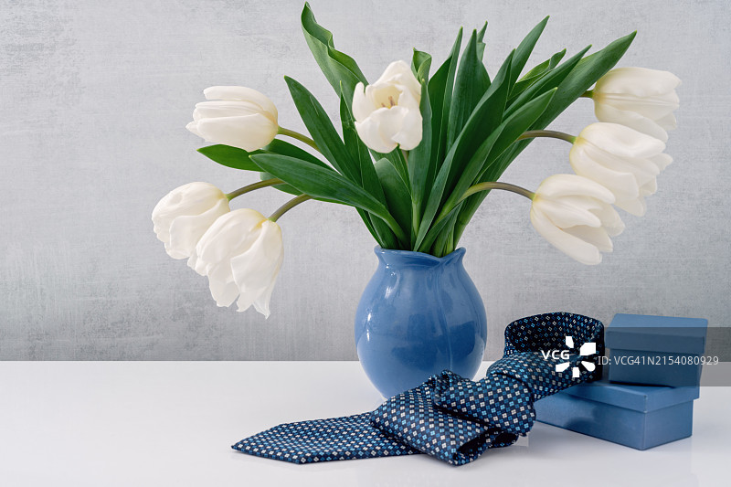 花瓶里的白色郁金香和父亲节领带的桌面侧视图图片素材