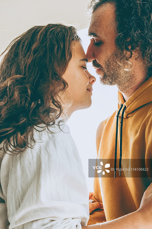 明亮自然光下，相爱的情侣即将亲吻的特写，捕捉到温柔亲密的瞬间图片素材