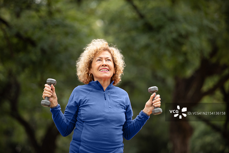 户外用哑铃锻炼的年长女性图片素材