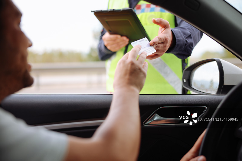 穿制服的警察对男司机进行交通管制图片素材