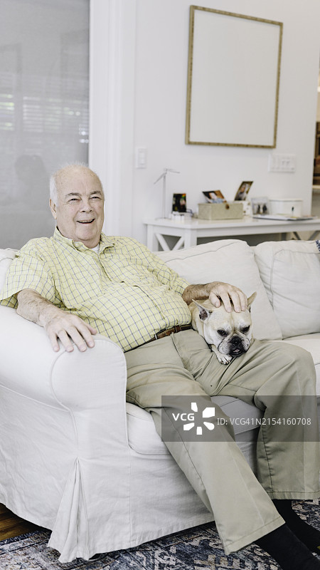 年长的拉丁裔男人和他的巴哥犬在家放松图片素材