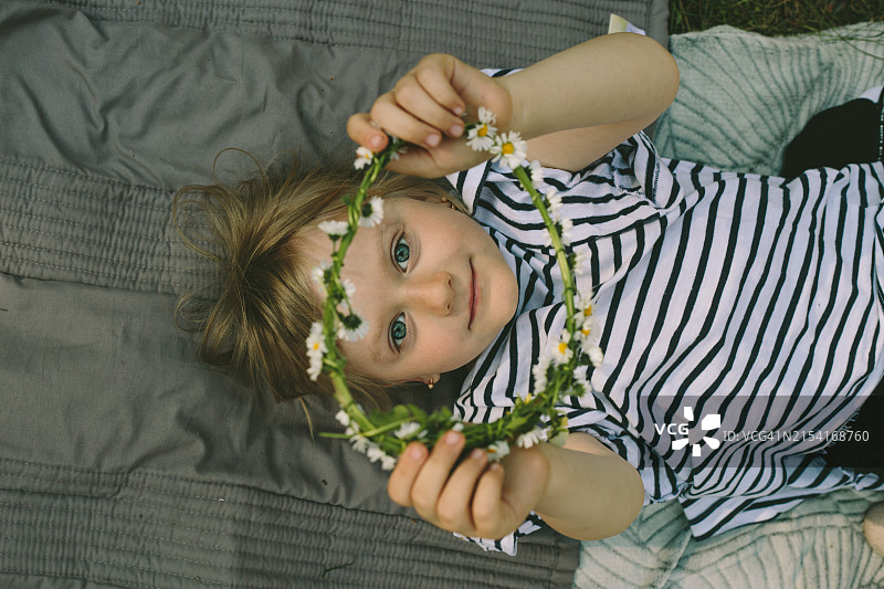 展示雏菊花环的可爱小女孩图片素材