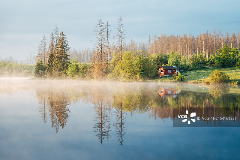 湖畔宁静的薄雾中一栋红色的房子图片素材