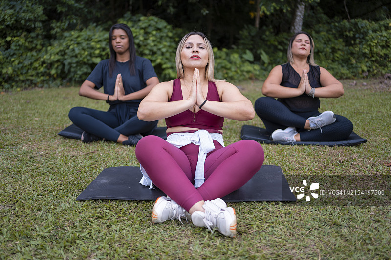 人们在绿地冥想图片素材