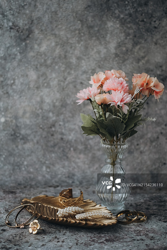 珠宝和金色托盘中的各种鲜花，深灰色表面图片素材