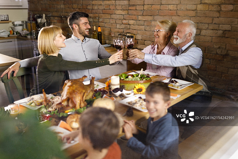 感恩节晚餐上敬酒的快乐大家庭图片素材