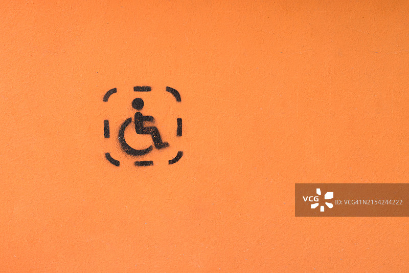 橙色街道墙壁上的轮椅人士图片素材