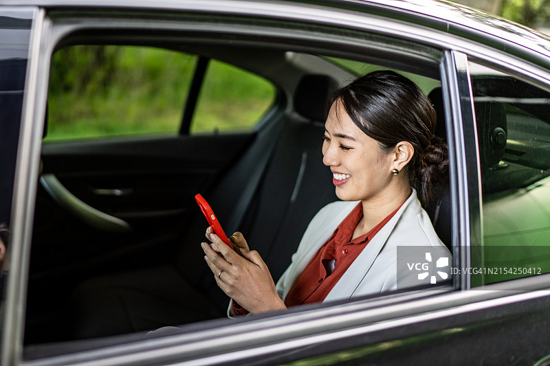 年轻漂亮的亚洲女商人正在车里使用手机图片素材